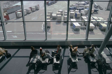 Passengers seat and wait for their flight on airport terminal.のeditorial素材