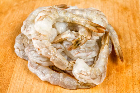 Raw peeled  Shrimps or Prawns On wooden board. Background. Close Up.の写真素材