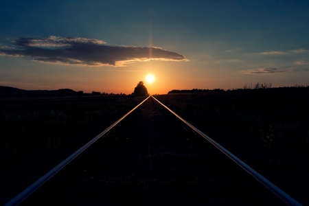 Sunset directly above railway railroad tracks.