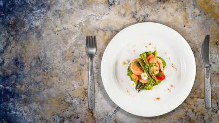 Prawns, asparagus and broccoli with edible daisy flowers. Top viewon granite counter top.の写真素材