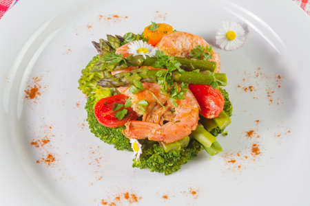 Prawns, asparagus and broccoli with edible daisy flowers.の写真素材