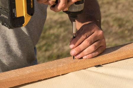 Roof construction building. Man using electrical scredriver to attach construction elements.の写真素材