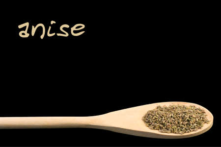 anise on wooden spoon isolated on black background. Latin name Pimpinellaの写真素材