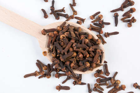 Cloves in wooden spoon isolated on white background. Closeup.の写真素材