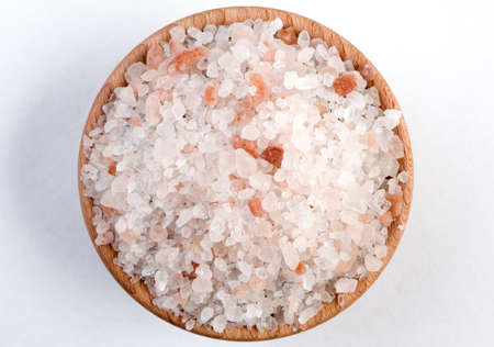 Himalayan pink salt  in wooden bowl isolated on white background.の写真素材