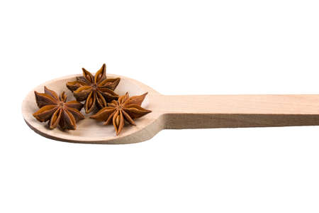 anise stars in wooden spoon isolated on white backgroundの写真素材