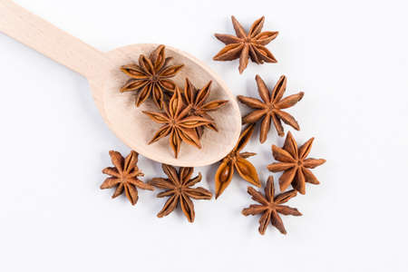 anise stars in wooden spoon isolated on white background. Closeup.  top viewの写真素材