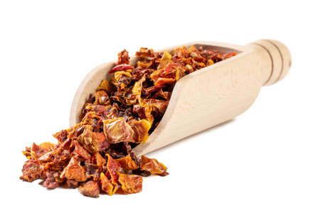 dried tomatoes in wooden scoop isolated on white background. spices and food ingredients