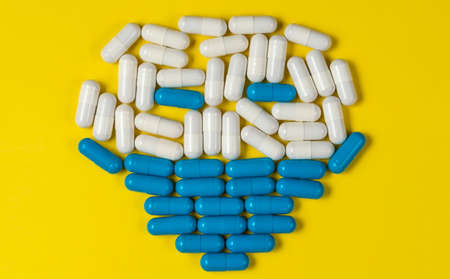 Face wearing mask made of  white and blue capsules pills.