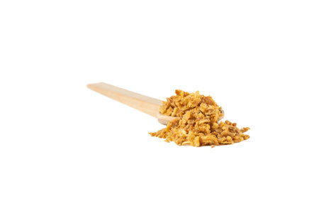 Crispy carmelized fried onion flakes in wooden spoon isolated on white background. Spices and food ingredients.の写真素材