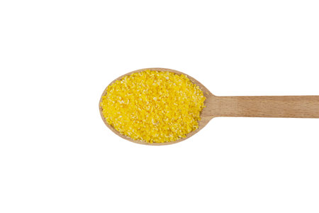 corn grits on wooden spoon isolated on white background. nutrition. food ingredient.の写真素材