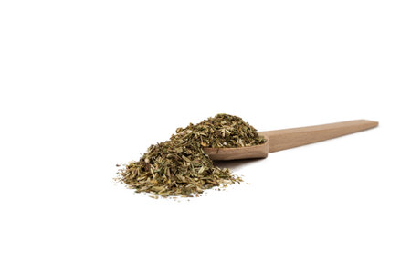 Dry Tansy Herb in latin Tanacetum vulgare on wooden spoon isolated on white background. Herbs. Alternative medicine.の写真素材