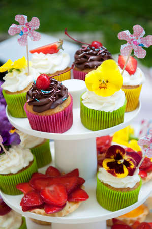 multicolored summer cupcakes with fruit and flowersの写真素材