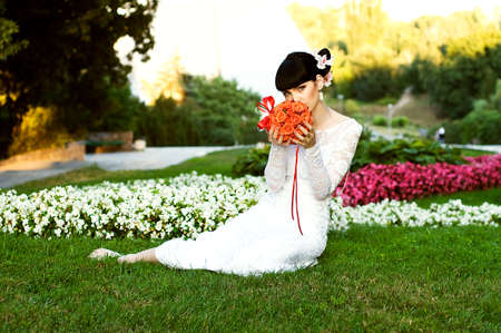 beautiful bride holding a bouquet of orange rosesの写真素材