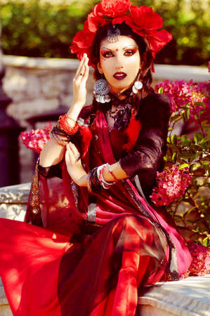 Indian woman with dramatic  makeup dressed in red sari