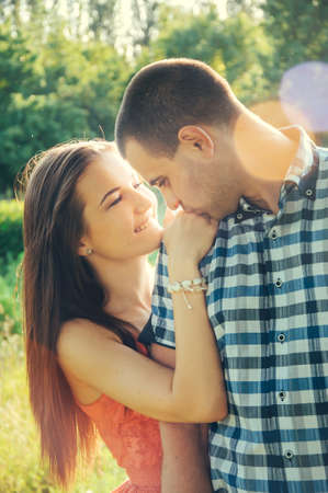 couple of young lovers hugging in the park in the sunsetの写真素材