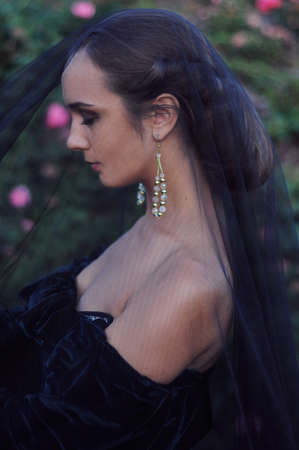 Young widow with closed eyes wearing black veil