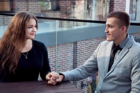 couple on a date in a cafe holding handsの写真素材