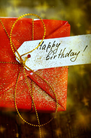 Red box of happy birthday present with golden ribbonの写真素材