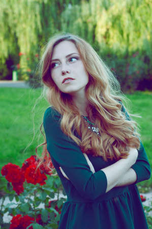 Cheerful caucasian woman with green eyes and green dress outdoors and  looking awayの写真素材