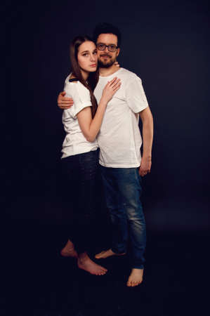 Young couple embracing and looking at each other wearing jeans and teeshirts. Casual style.の写真素材