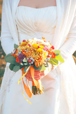 Autumn bride holding beautiful bright bouquet with eucalypthus leavesの写真素材