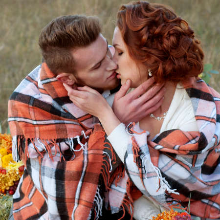 Bride and groom together in the field. Romantic autumn outdoor setting.の写真素材
