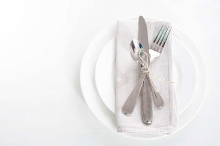 Table setting in white and gray colors with linen napkins and silverwareの写真素材