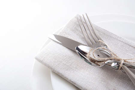 Table setting in white and gray colors with linen napkins and silverwareの写真素材
