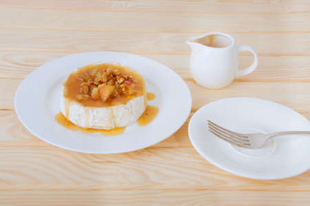 Camembert cheese with honey sauce with nuts and butter. Waiter adding sauce to the dish.の写真素材