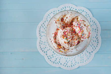 Vanilla ice cream in bowls sprinkled with chocolate and multicolored sprinklesの写真素材