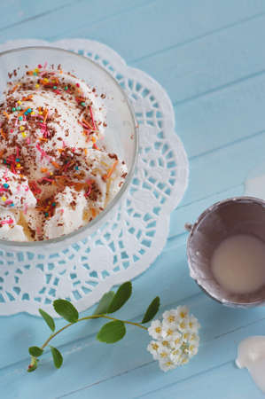 Vanilla ice cream in bowls sprinkled with chocolate and multicolored sprinklesの写真素材