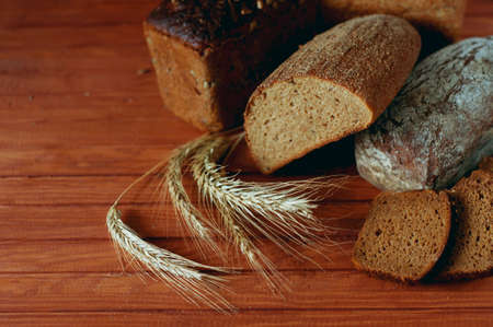 Set of different kind of bread types on wooden table made of various grains and cerealの写真素材