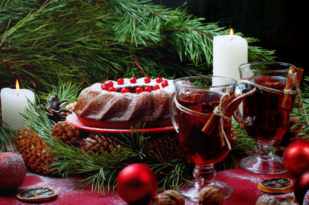 Christmas table setting. Bundt cake pudding sprinkled with sugar powder decorated with and mulled wine.の写真素材