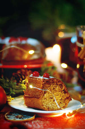 Piece of christmas pudding cake on white saucer decorated with berries sprinkled with sugar powder. Traditional christmas food.の写真素材