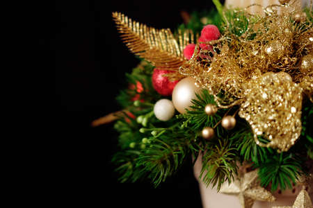 Christmas holiday centerpiece decor with fir branches, golden leaves, red berries and white candleの写真素材