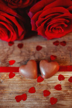 Valentine's Day celebration present chocolate heart candies and red roses symbol of love and passionの写真素材