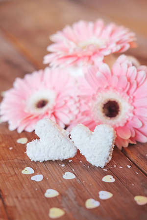 Valentine's Day symbols tender pink gerbera flowers and heart shaped coconut candiesの写真素材