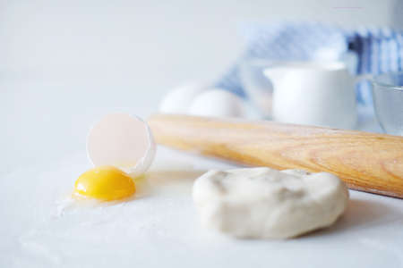 Cooking stages. Preparing dough for pies fresh eggs, flour and milk ingredients on table.の写真素材