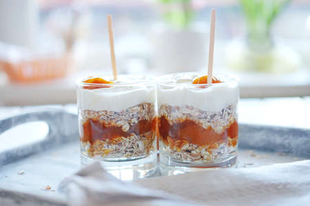 Oats layered with spicy and sweet apricot jam and cream served for breakfast. Healthy food concept.の写真素材