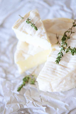 Brie cheese on wrapping paper with thyme herbsの写真素材