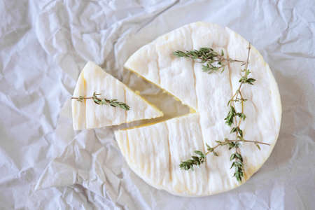 Brie cheese on wrapping paper with thyme herbsの写真素材