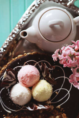 Holiday meal concept. Sweet chocolate cake with peanuts, shredded coconut flakes and tea.