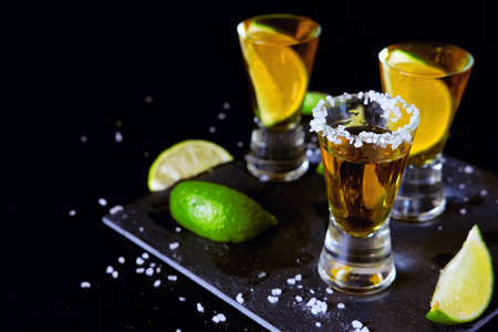 Strong alcohol drinks. Tequila glass shots in the bar with salt and lime slices.の写真素材