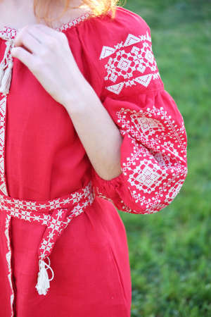 Detail of traditional Ukrainian costume vyshyvanka dress made of red linen fabric and white cross...