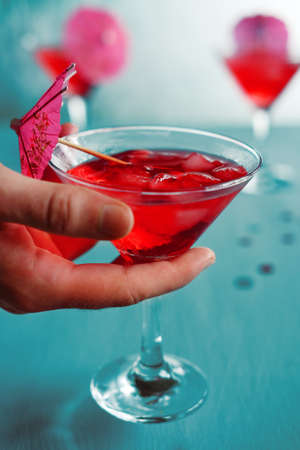Raspberry cocktail with ice and paper umbrellas. Summer refreshing alcohol drinks for parties.