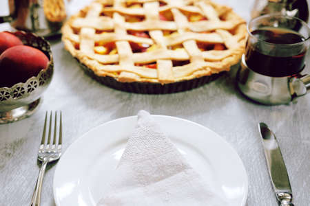 Tasty summer sweet pie with peach filling, tea and peaches. Table setting for lunch.の写真素材