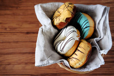 Fresh sweet doughnuts with multi colored icing and chocolate frosting. Fast food.の写真素材