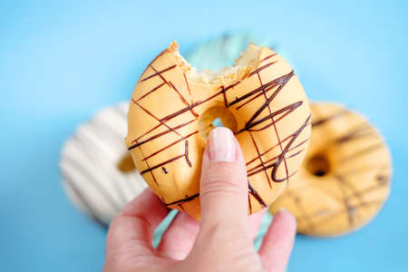Fresh sweet doughnuts with multi colored icing and chocolate frosting. Fast food.