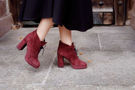 Retro styled portrait. Teacher woman in old fashioned classic outfit wearing burgundy suede boots on heels at the entrance.の写真素材